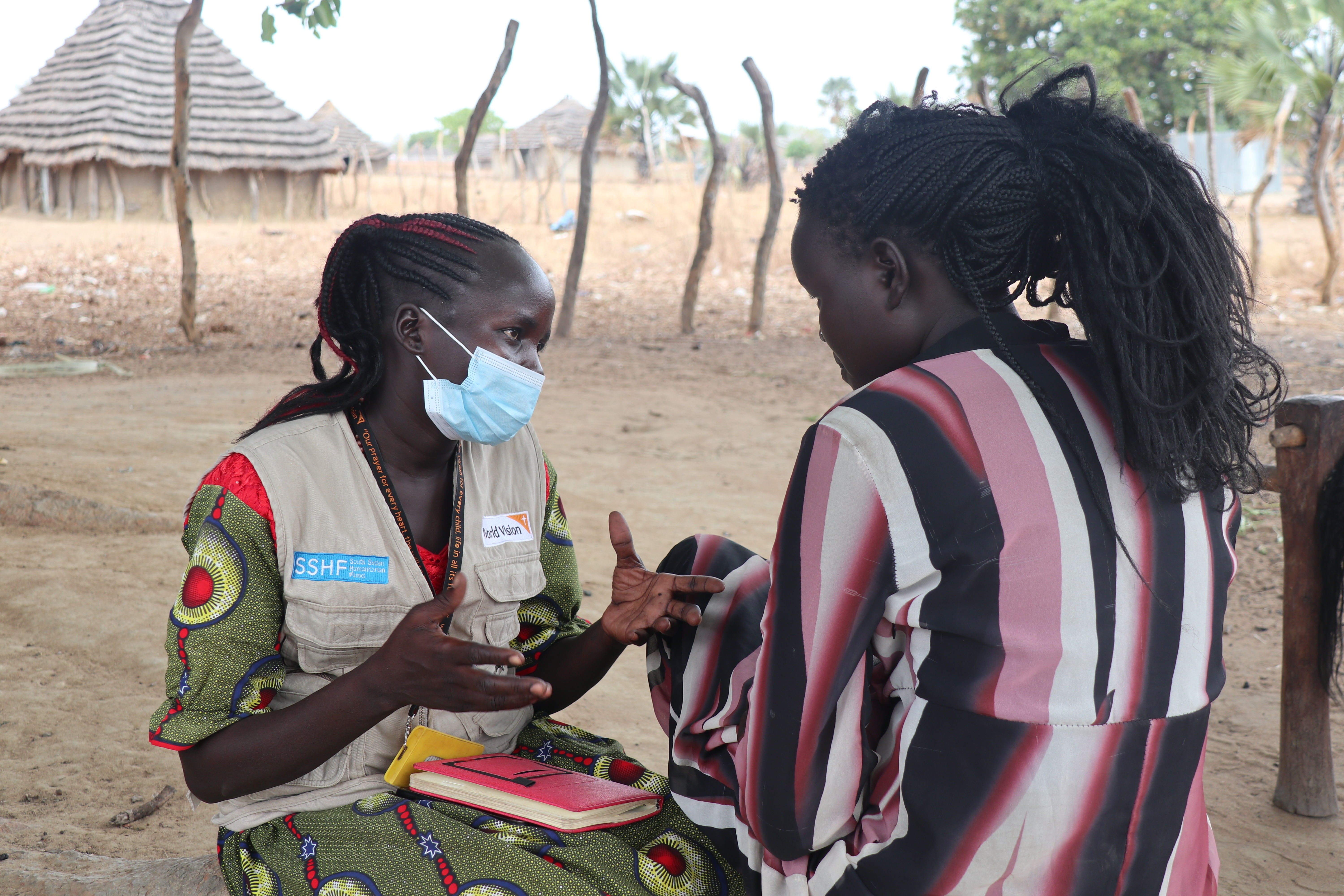 World Vision’s social worker Pasquina Diu talks with South Sudanese girl Katina on one of her visits.