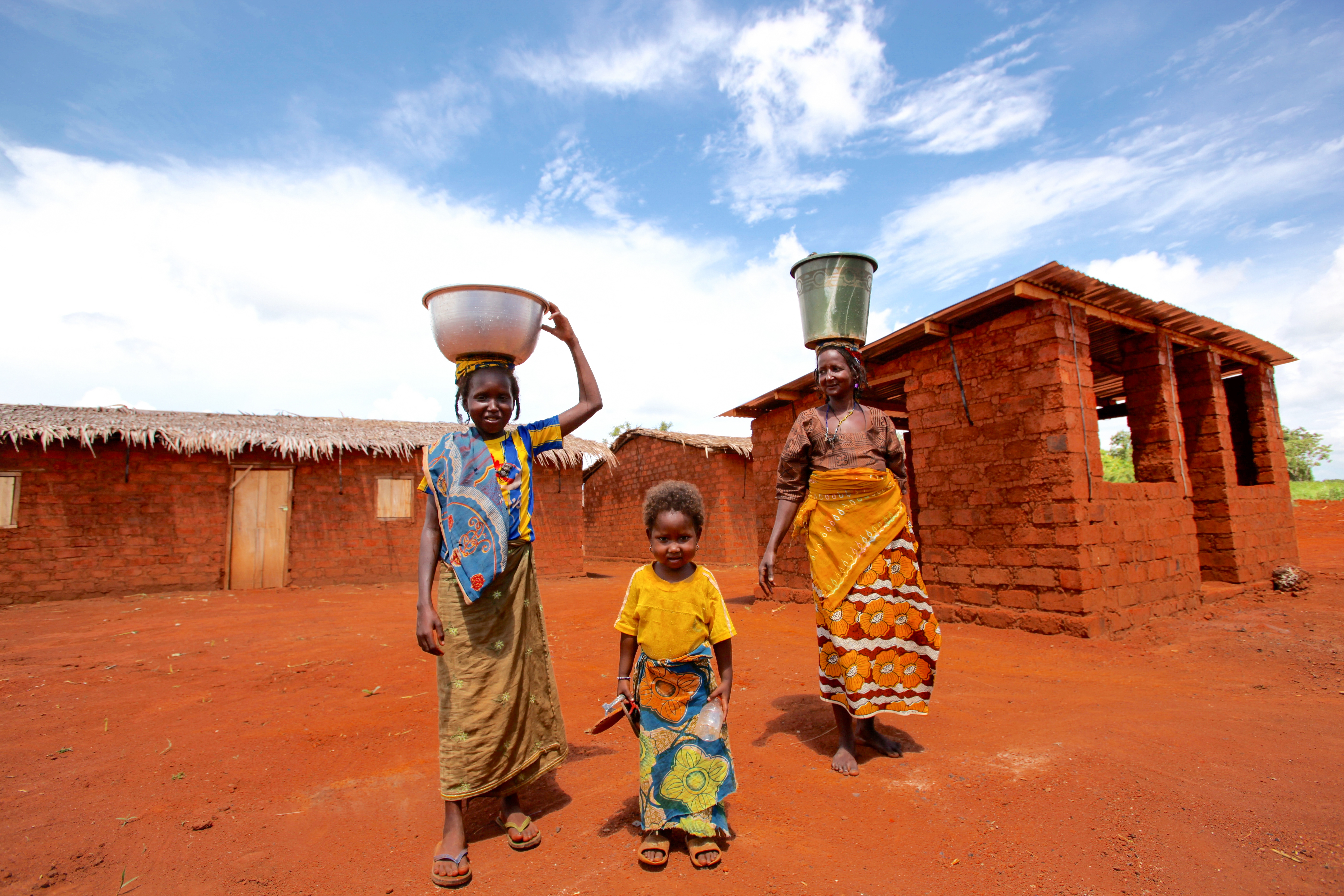 mother and 2 children carrying water