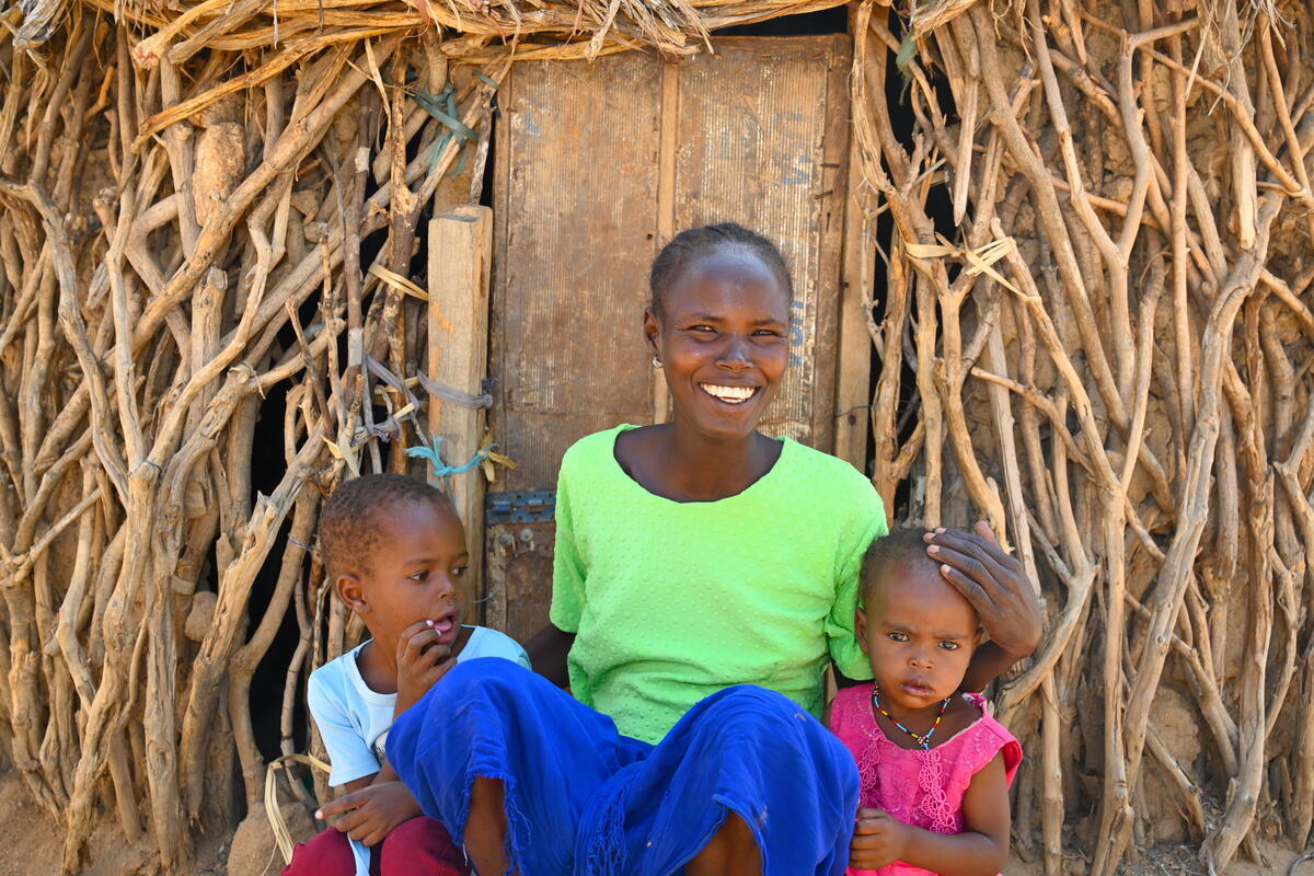 Kenyan mother sat between her two young children