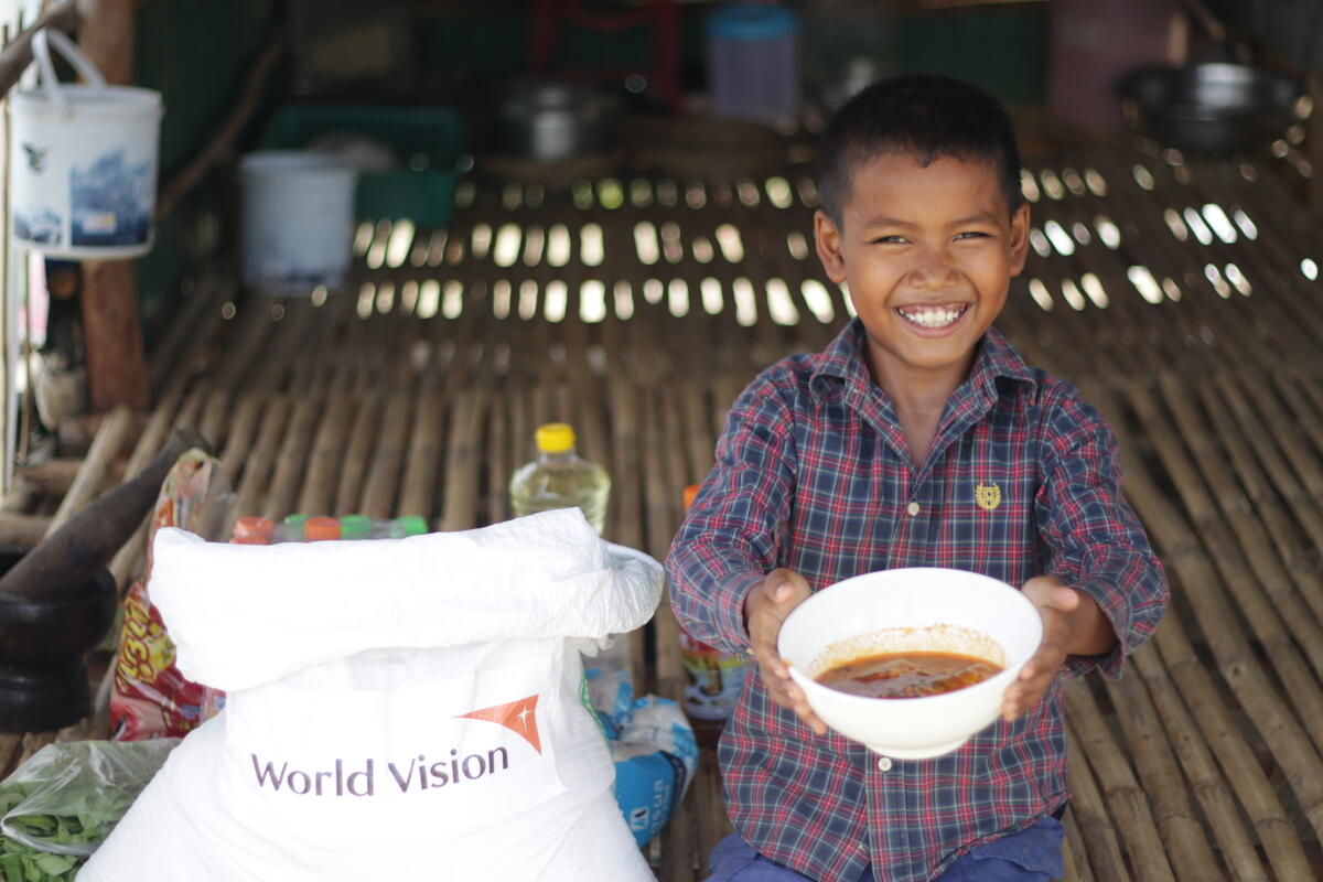 10-year-old Doeurn is pictured with food from the emergency food support package provided by World Vision Cambodia