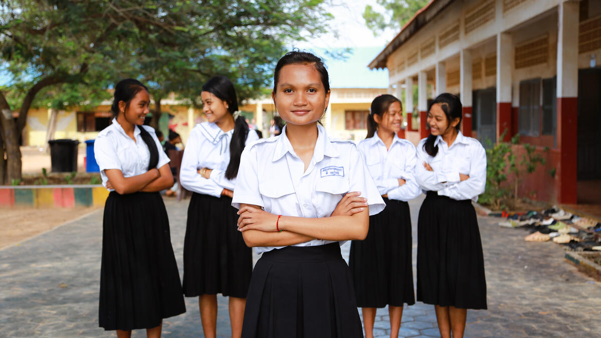 Cambodian school girl standing in the centre in front of four other Cambodia girls
