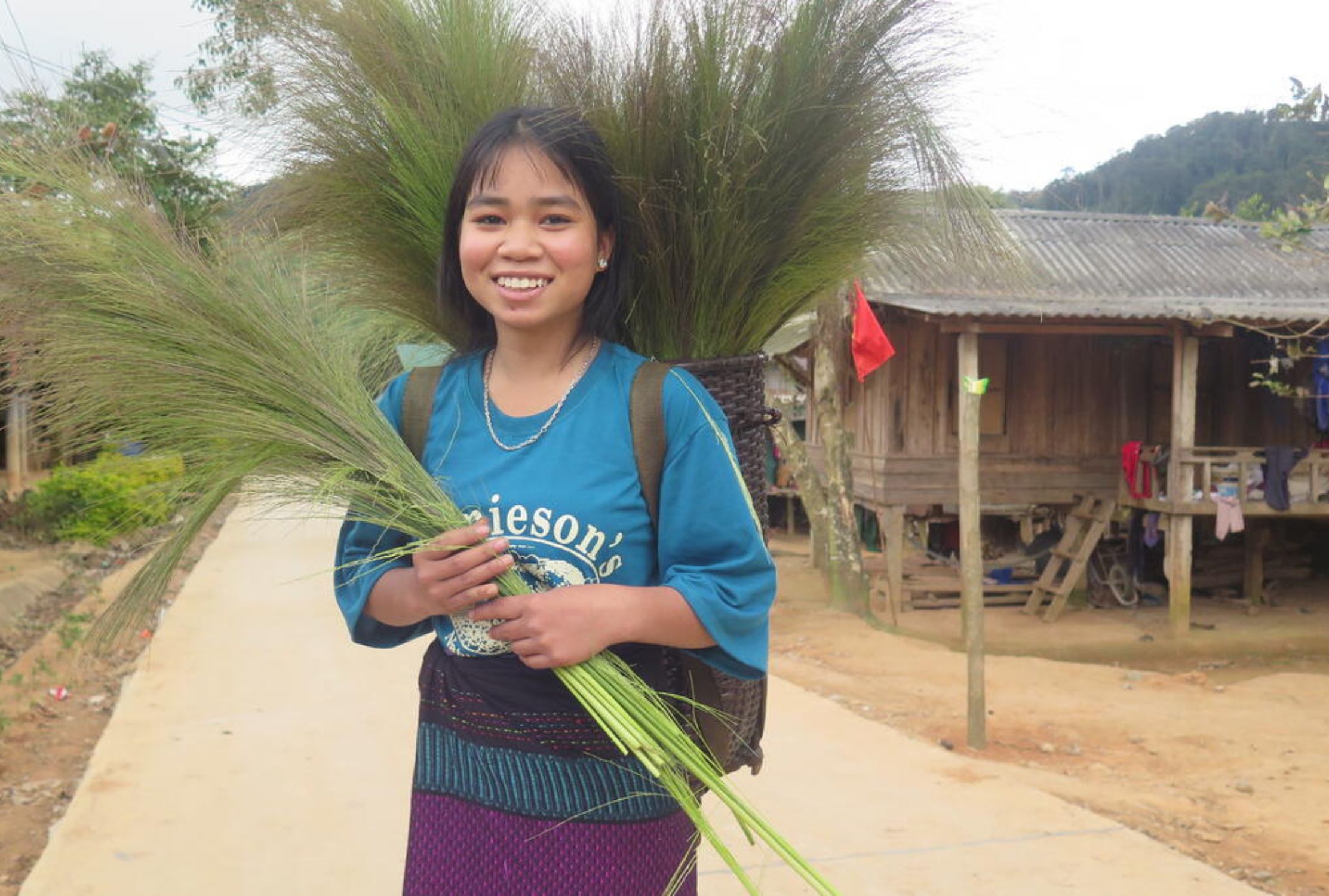 Vietnamese girl smiling and holding grass harvest