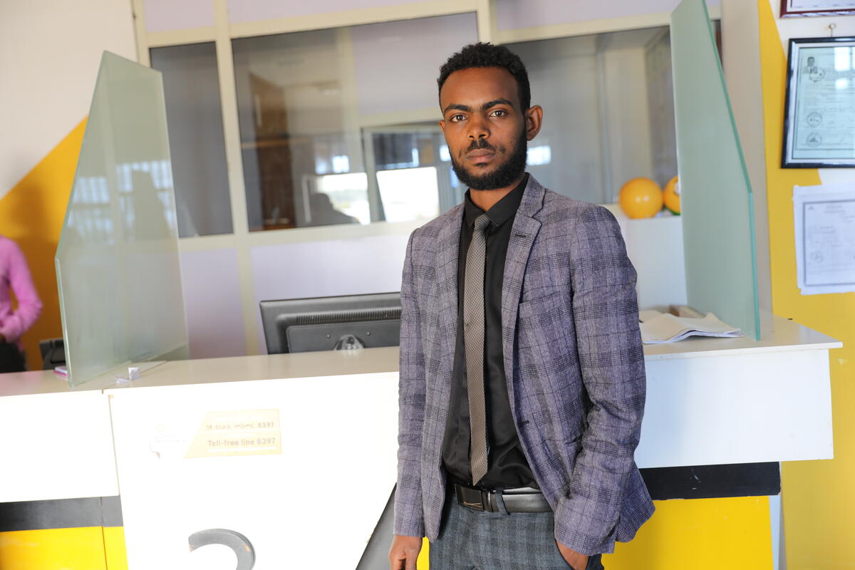 Geteneh poses in the reception of the bank he works