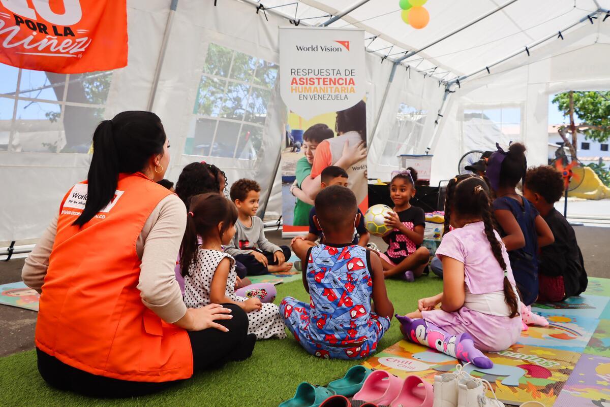 WV staff member sitting in a Child Friendly Space with children in Venezuela.