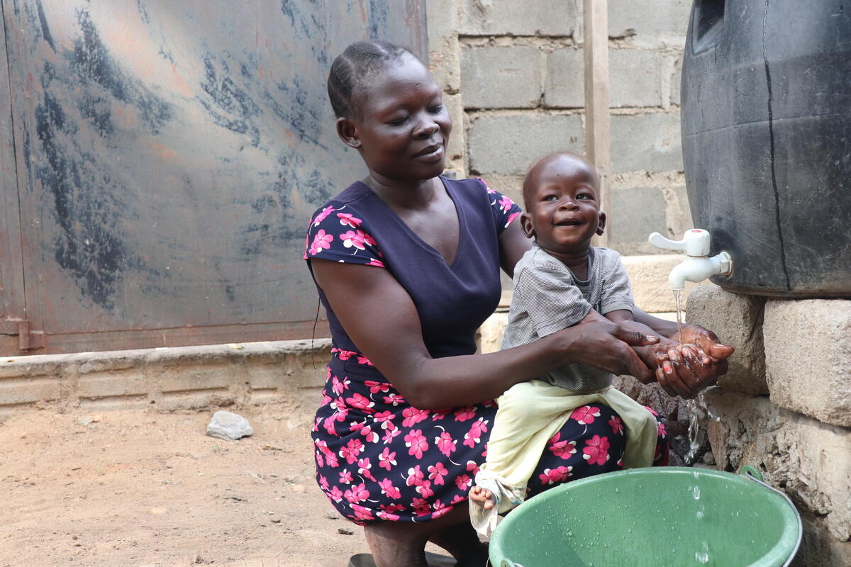 Susan uses the water pump with her son, David.