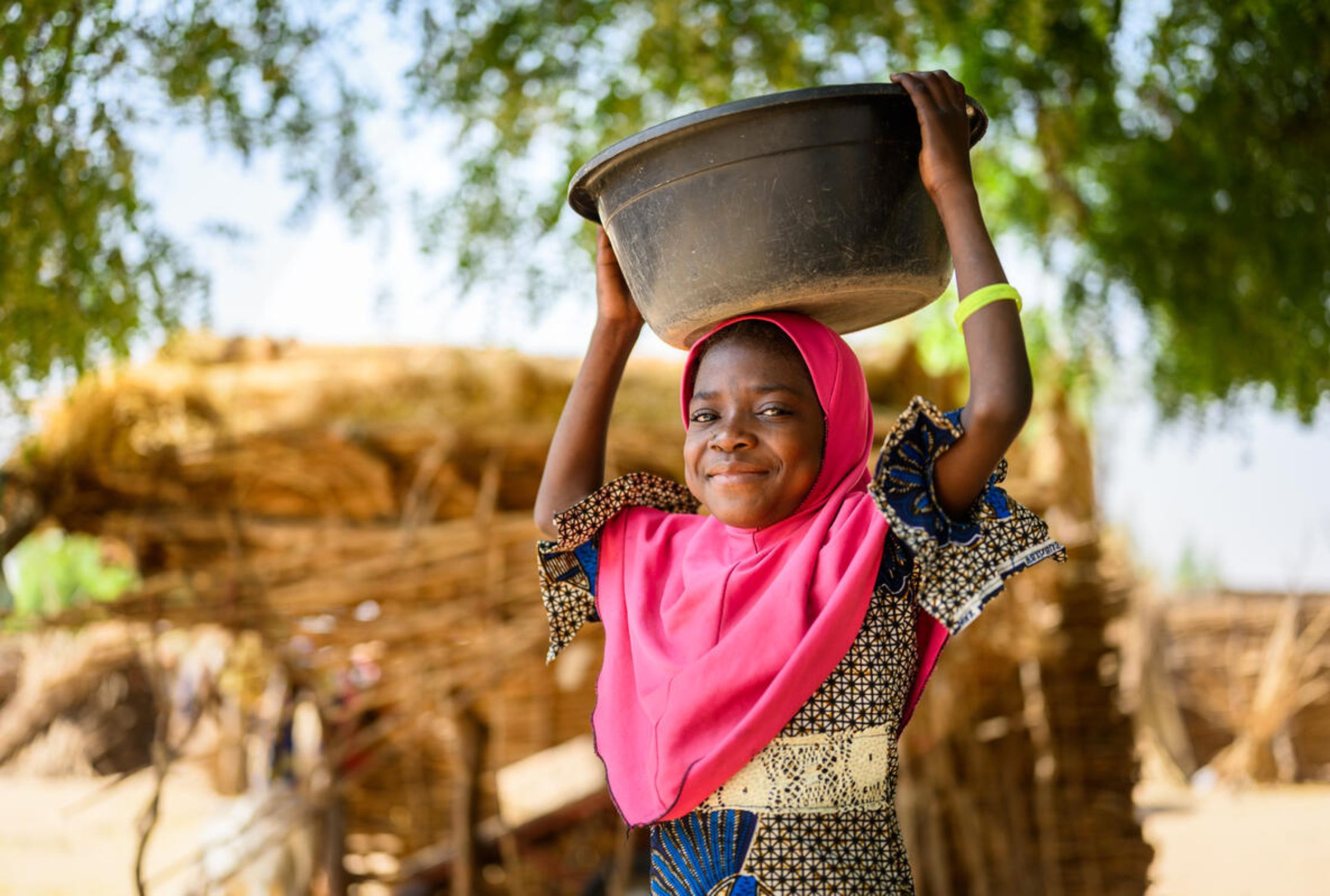 Nigerien nine-year-old girl carrying a water basin on her head