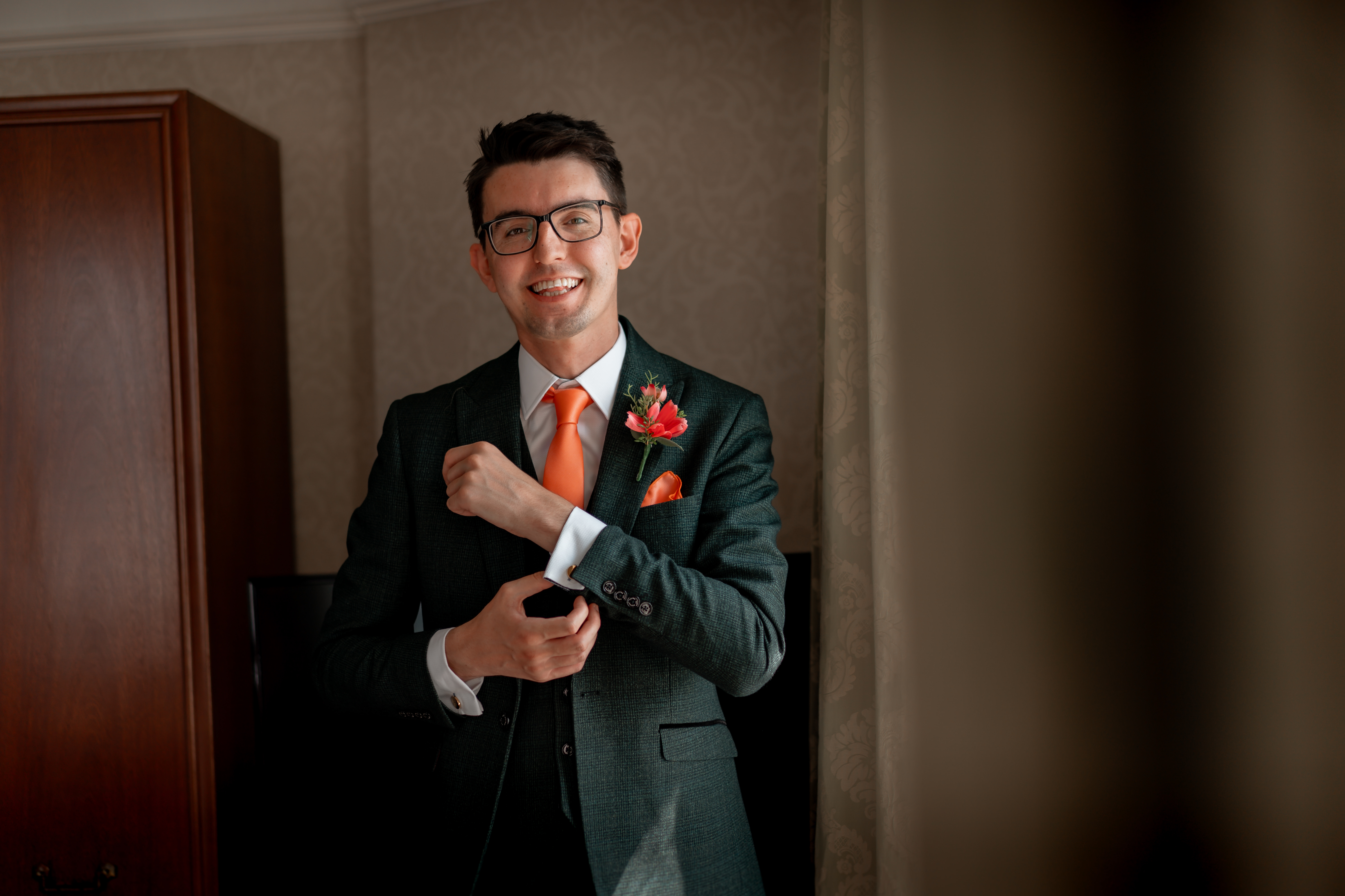 Sam grins in a photo. He's wearing a suit.