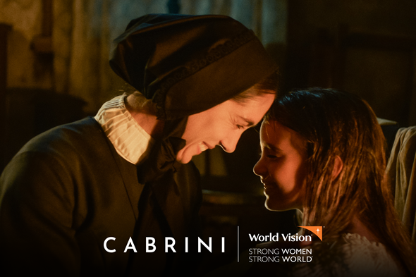 A still from Cabrini showing the main character smiling and touching foreheads with a young girl. 