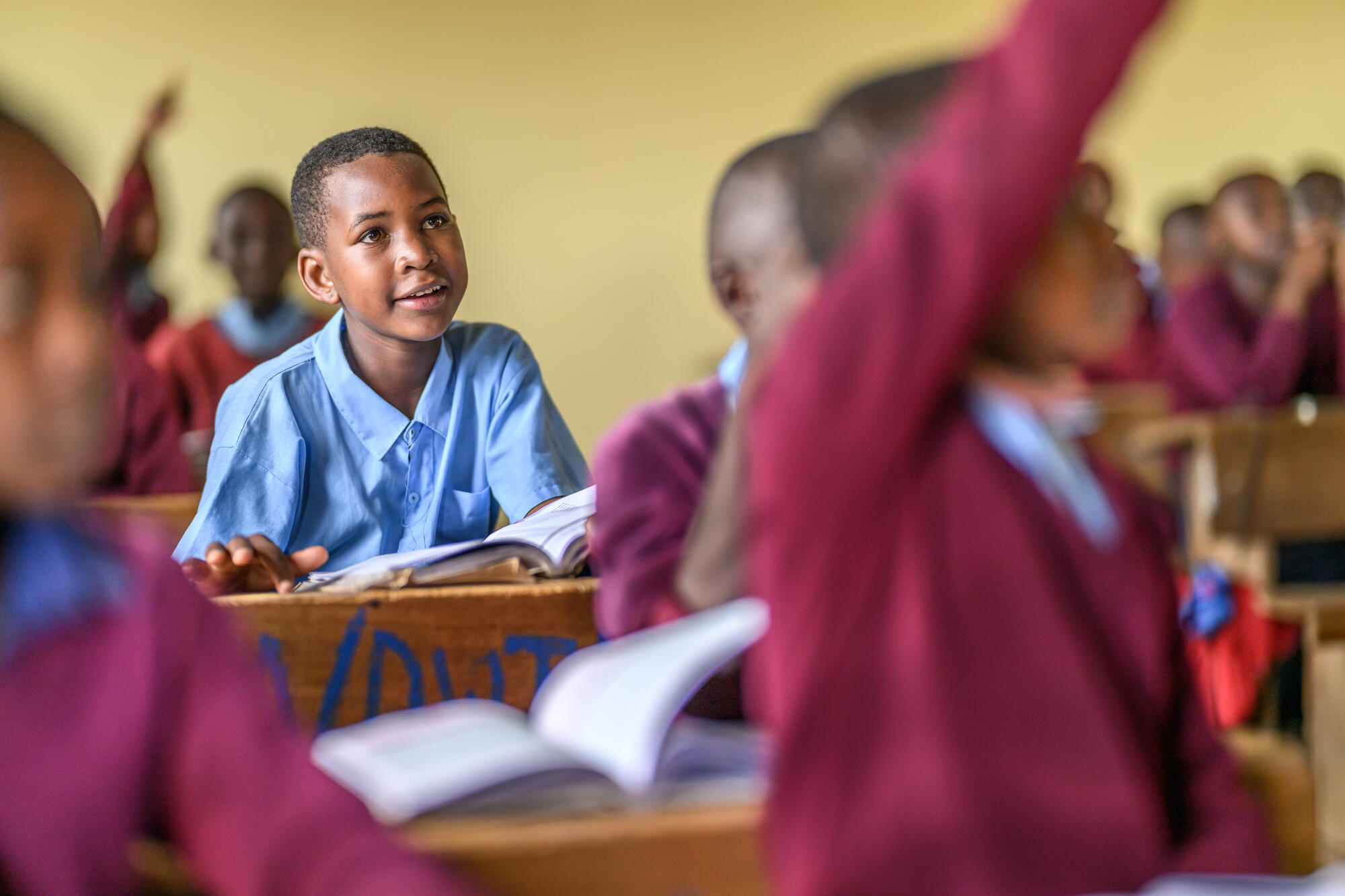 A girl in Tanzania stands in front of a dark background and soft white lights