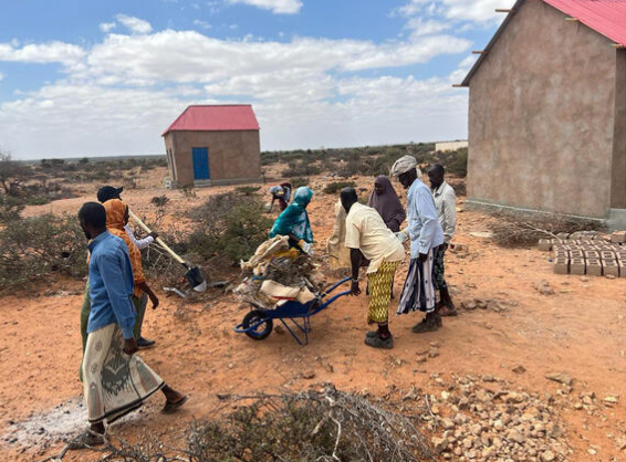A group of men clearing rough ground