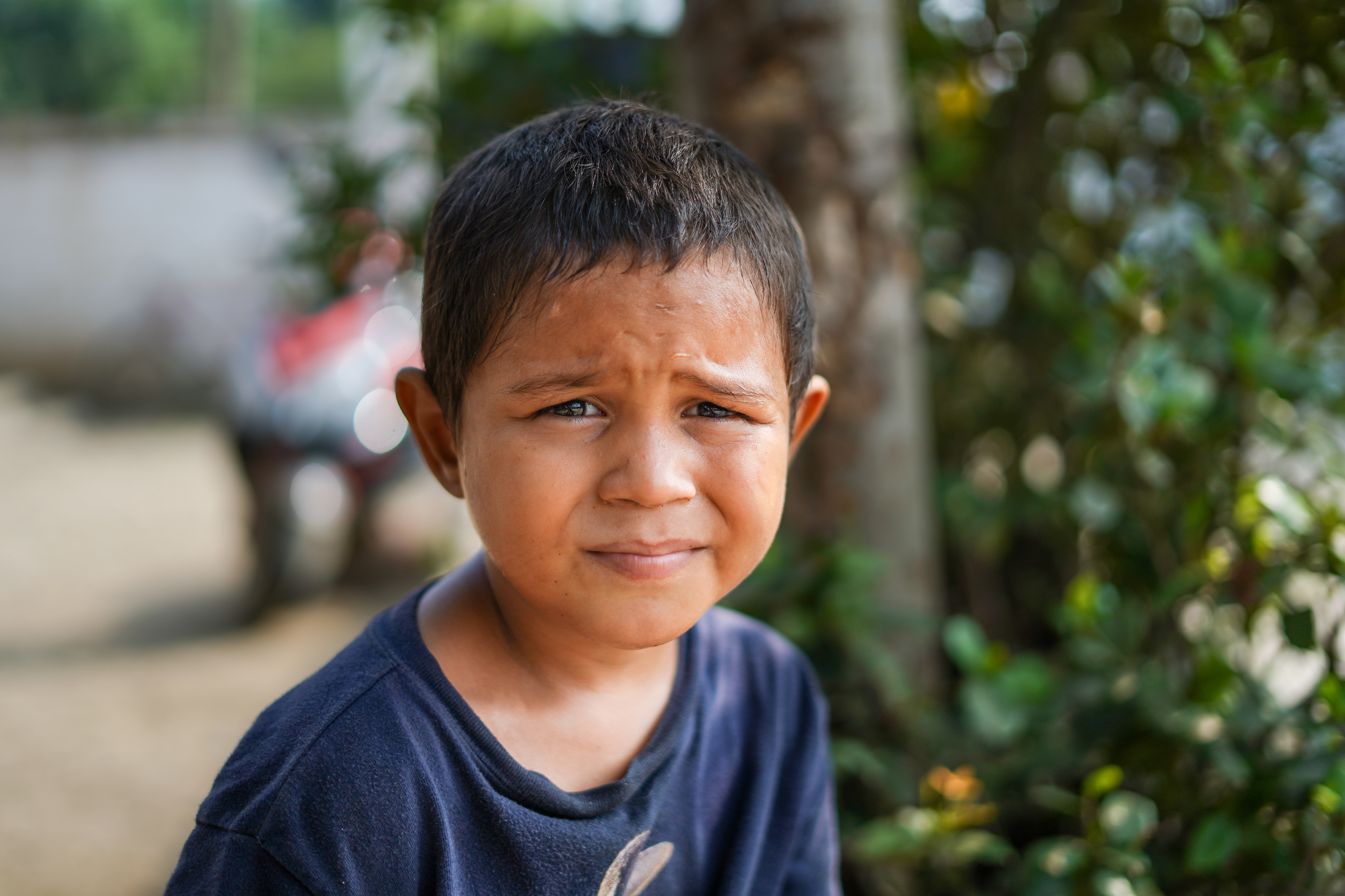 A young boy from Honduras, standing outside.