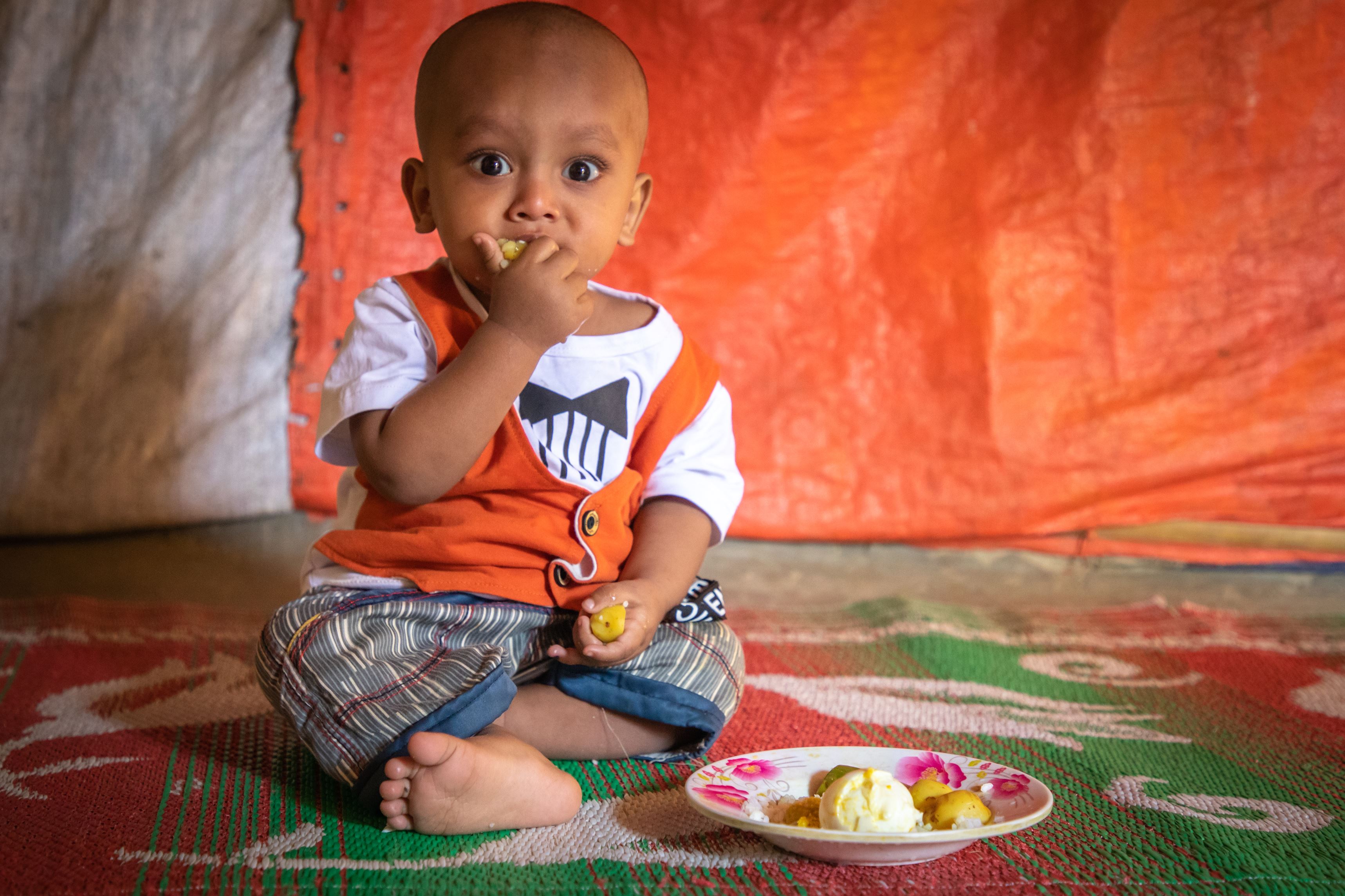 Young toddler feeds from a bowl