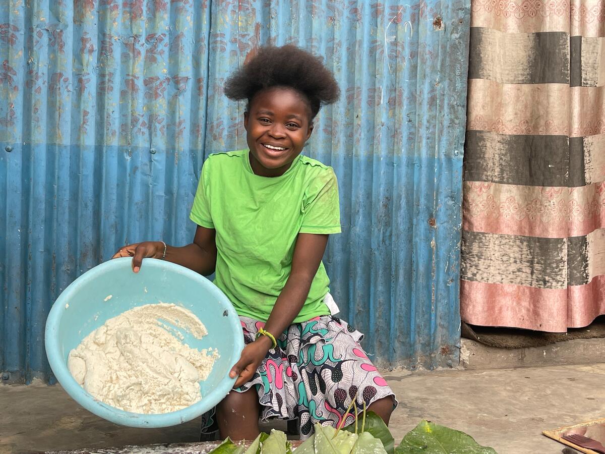 16-year-old sponsored girl in DRC holding a bowl with dough for Cassava bread