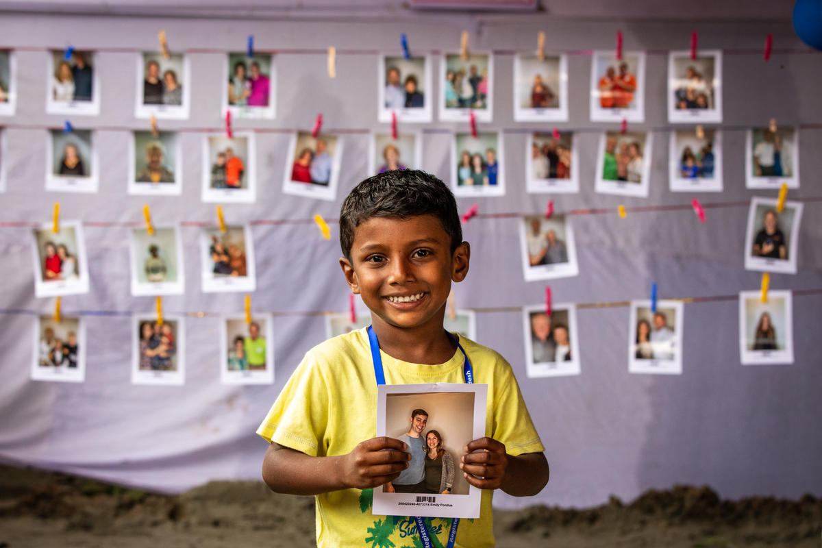 Fahin stands with a photo of the person he's chosen as his sponsor