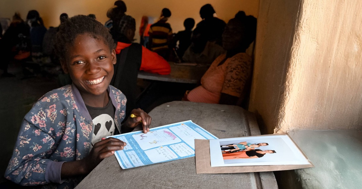 A young girl in Zambia writing a letter to het sponsors