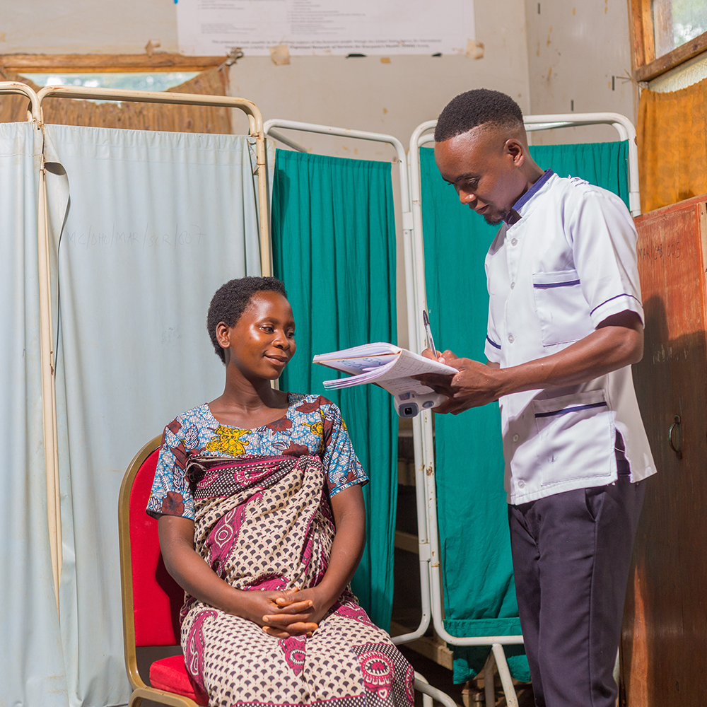 A woman is treated by a community healthcare volunteer