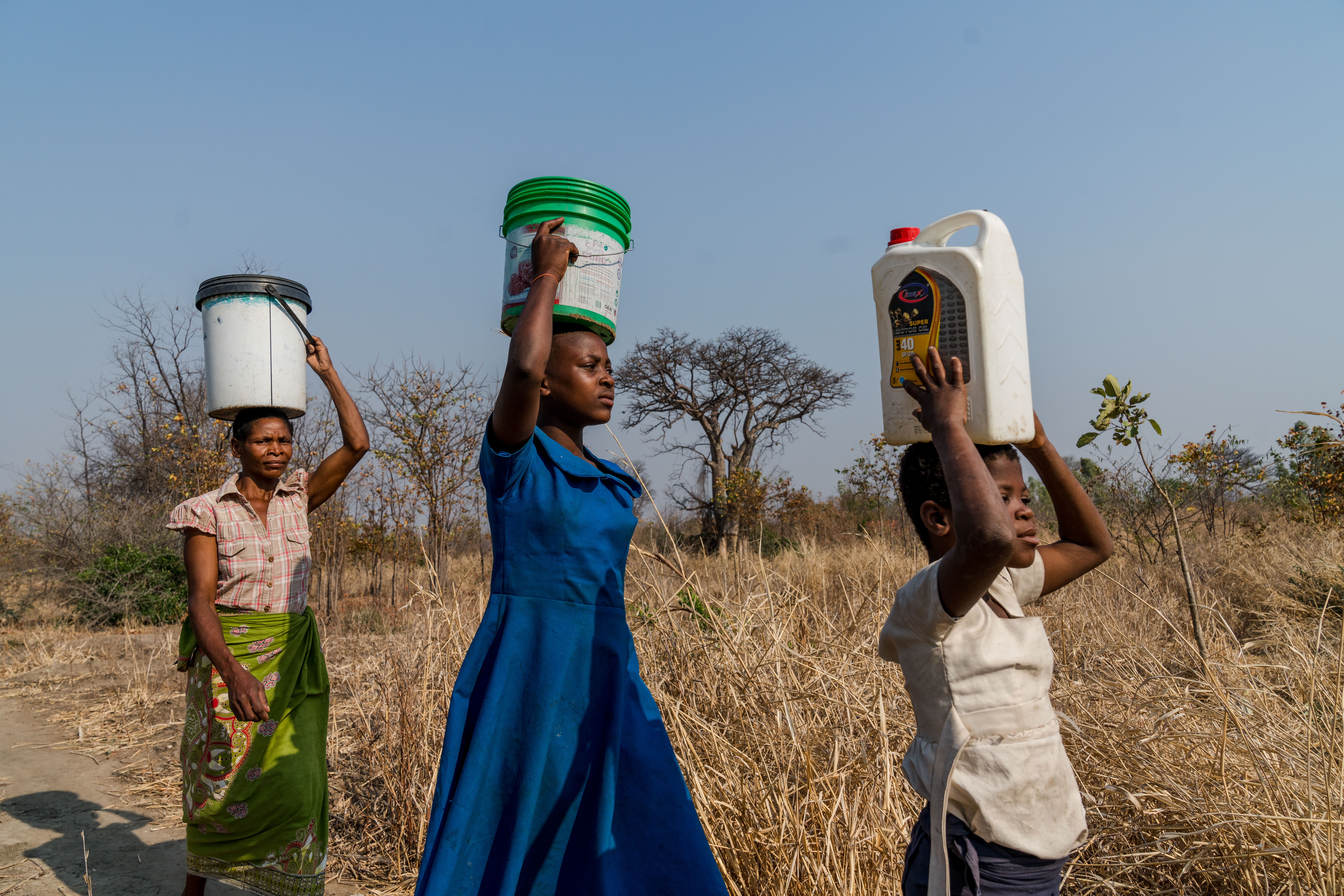 Girls carry buckets of water