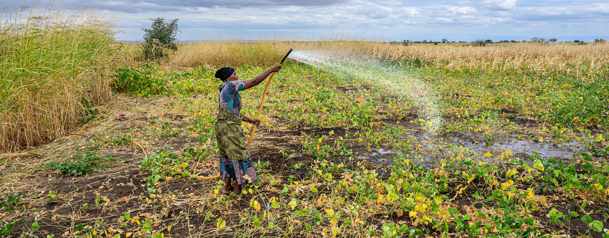 A girl in Tanzania stands in front of a dark background and soft white lights