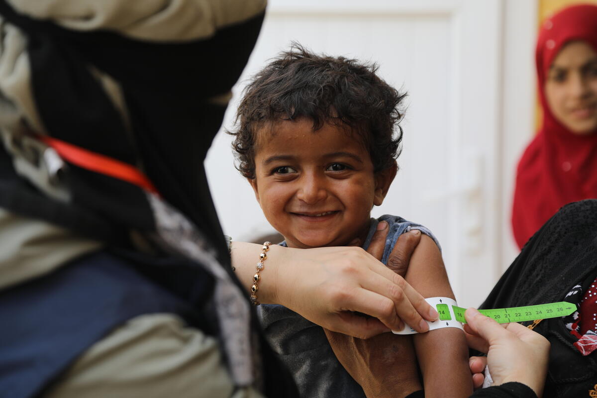 Child being checked for malnutrition with a tape.