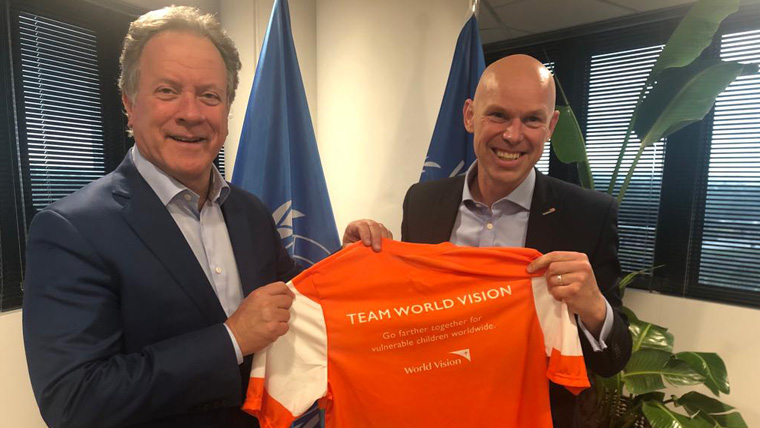 To celebrate their 30-year partnership, representatives of WFP and World Vision hold an orange T-shirt together