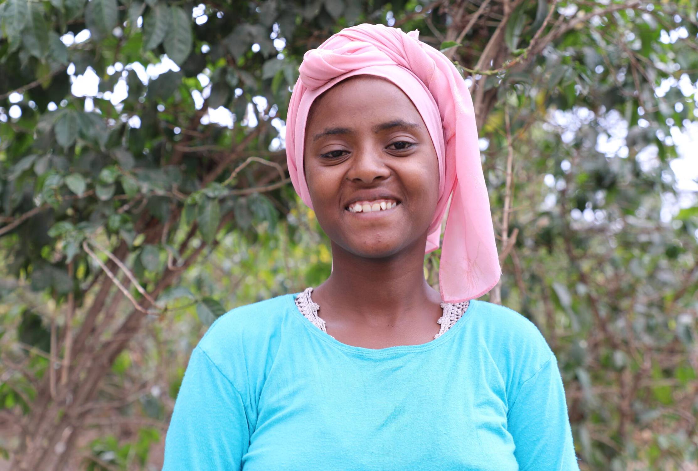 Girl from Ethiopia wearing a head wrap looking at the camera and smiling