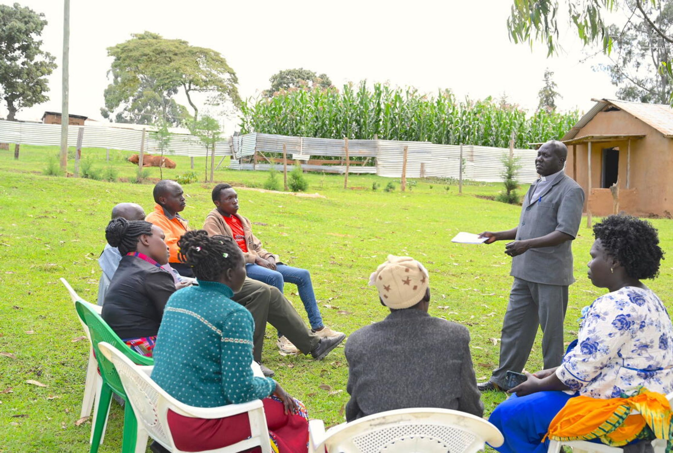 World Vision and community pastor standing and speaking to a Kenyan community
