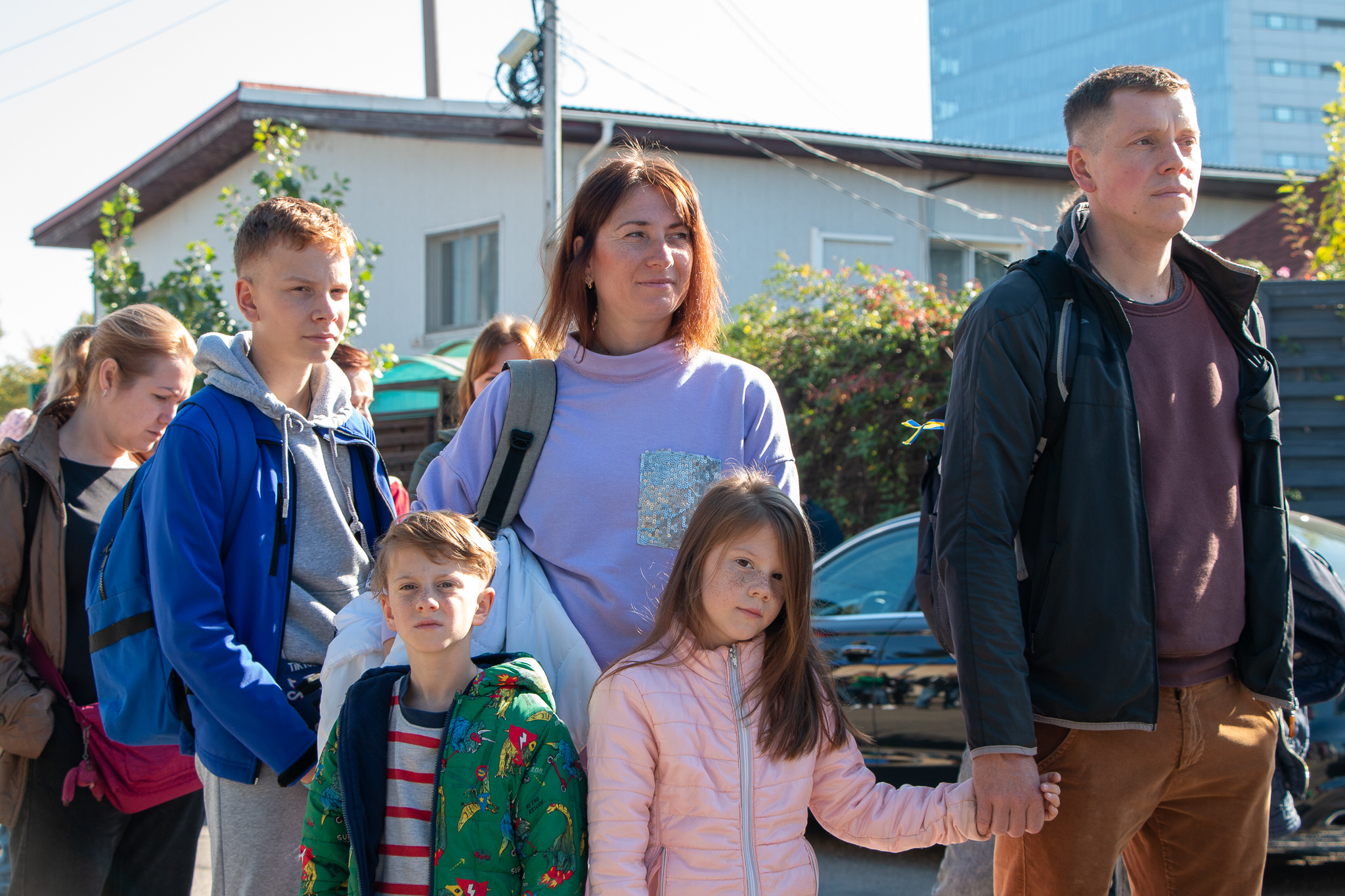 Ukrainian family standing in a queue to receive food and non-food items