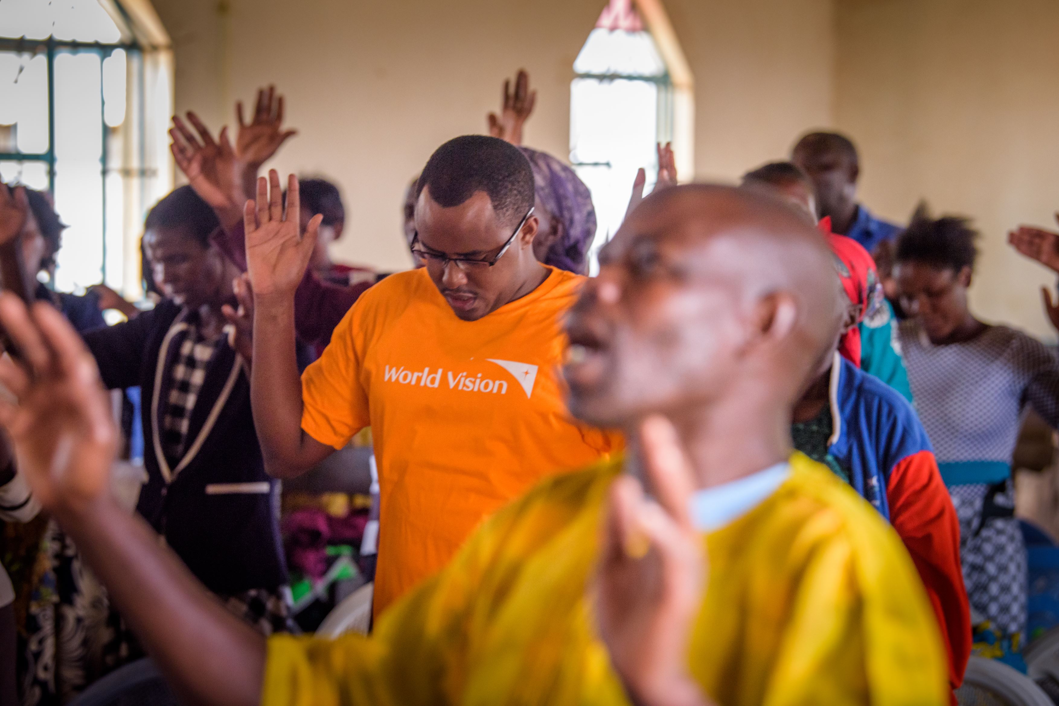 Kenyan church and congregation worshipping with World Vision staff too