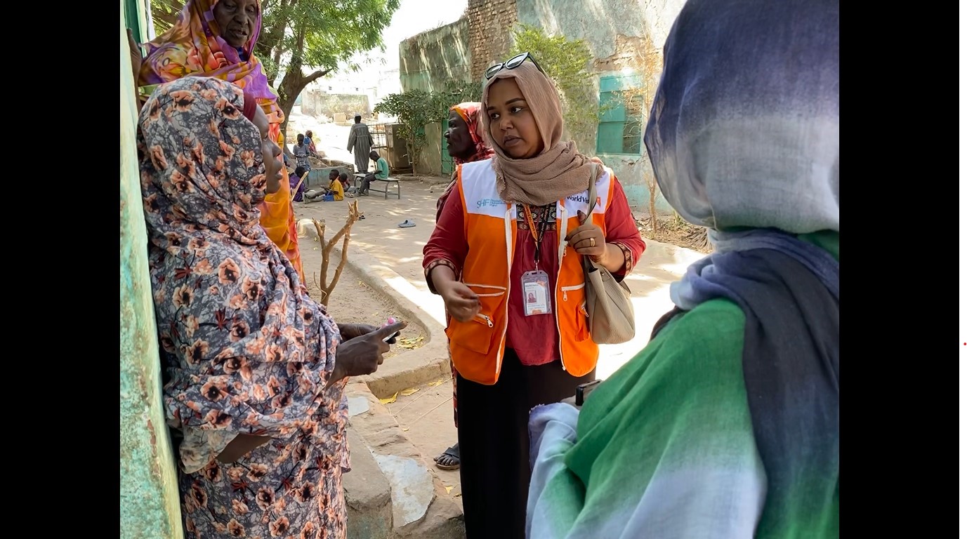 Sudan World Vision staff member with ladies from the community