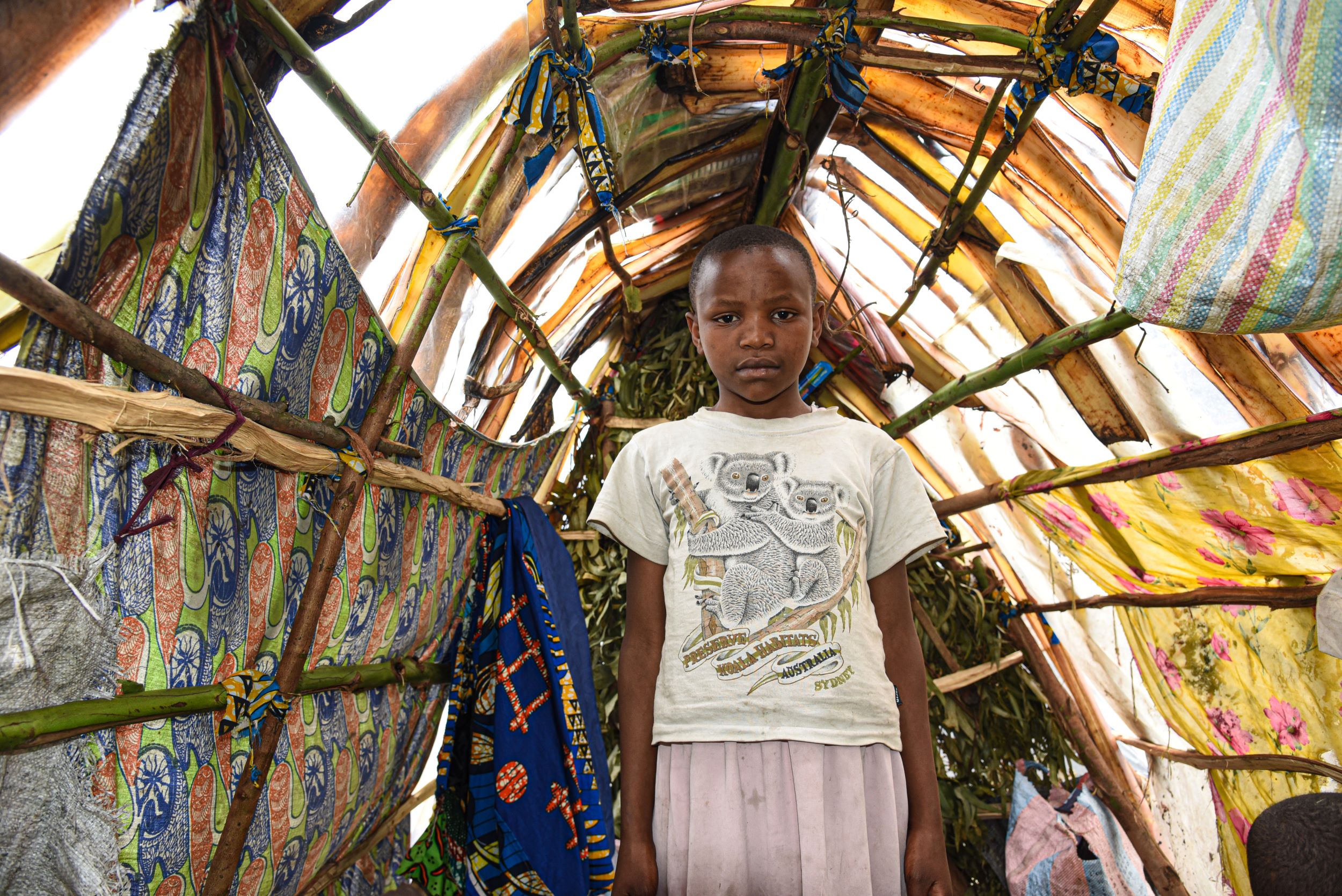 Ten-year-old Congolese girl in the makeshift shelter she shares with her family