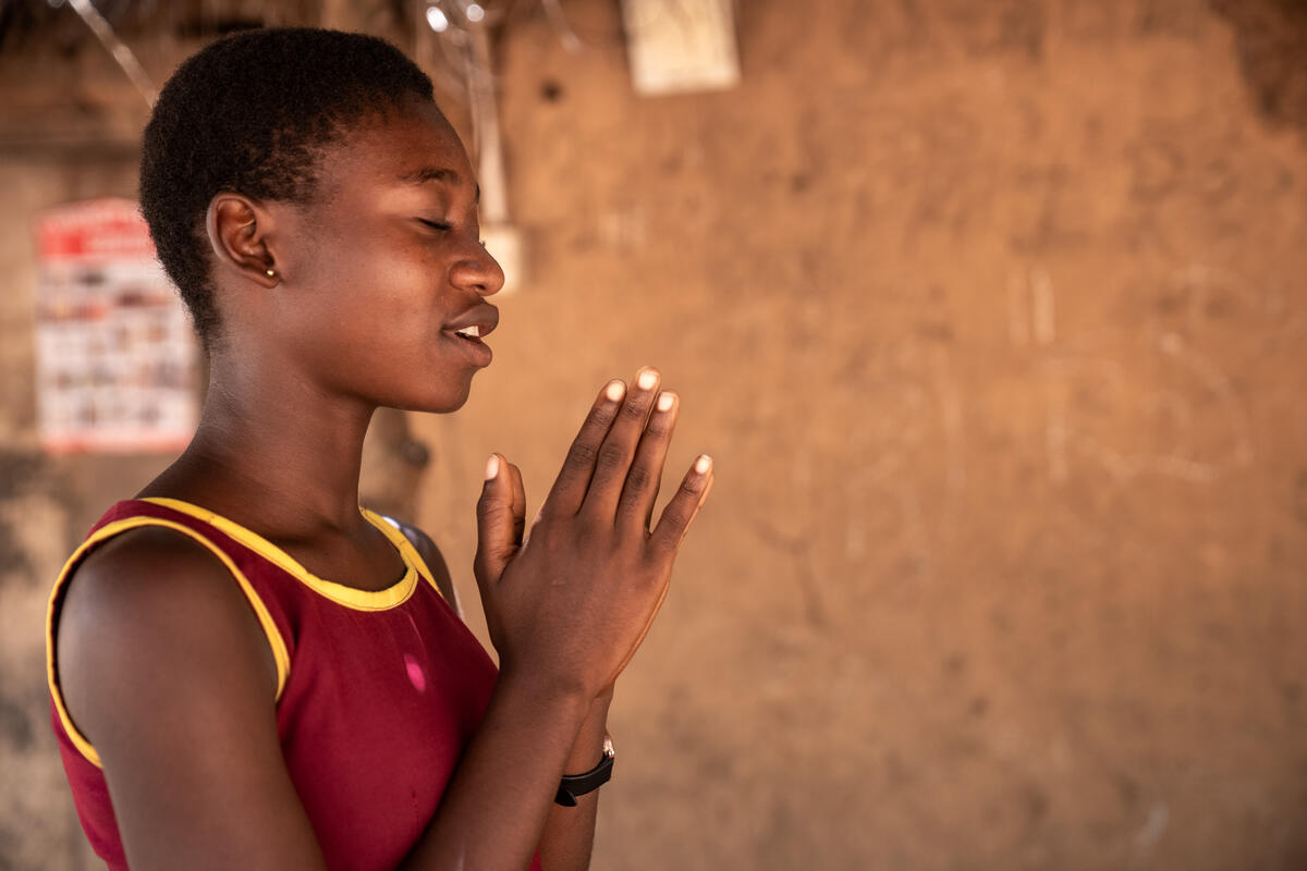 Ghanaian girl holding her hands together in prayer