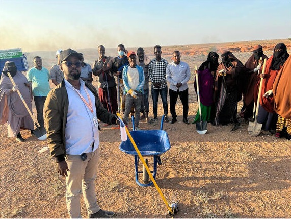 A group of men with gardening tools.